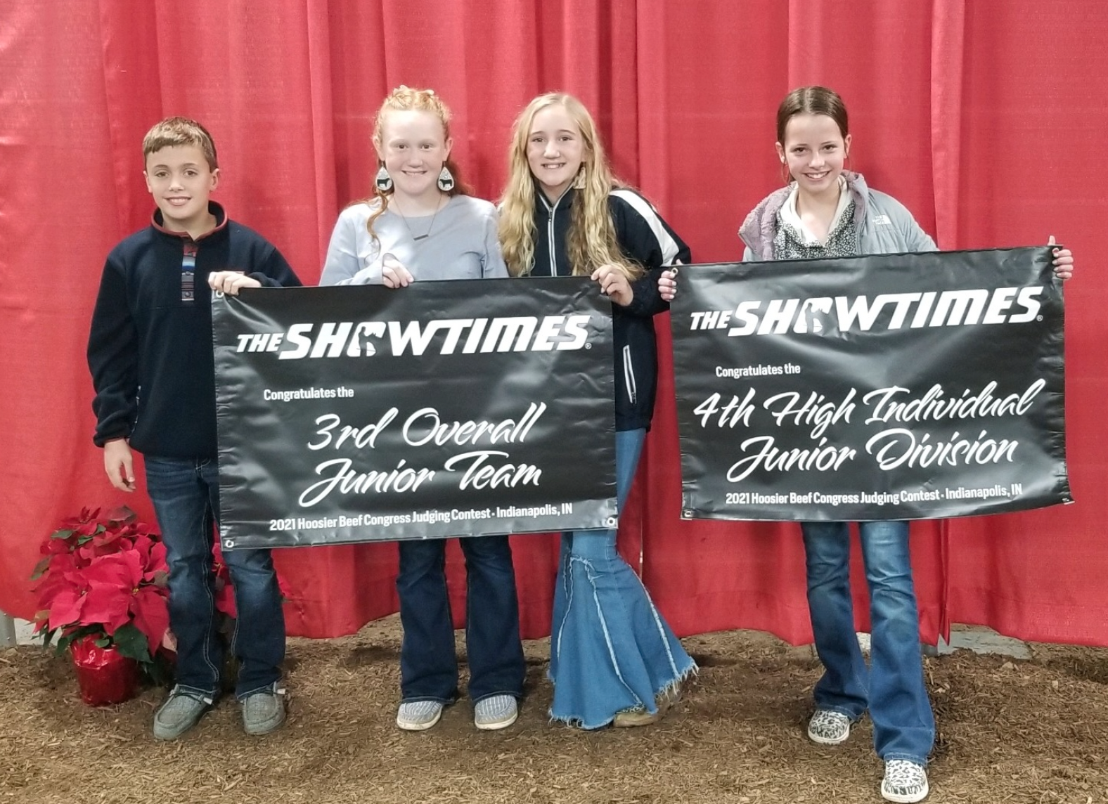 Garrett Larson, Emma Powell, Ellie Powell, and Claire Cloud hold banners showing their placement in the contest.