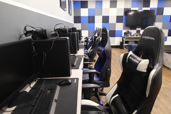 Row of PCs and chairs. Shows the blue/white backsplash of the room. 