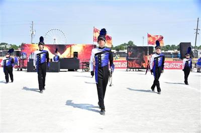 Students in black, white, and dark blue uniforms strike a pose together during the performance. 
