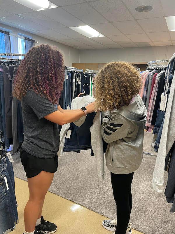 Two students shop for clothing at My Closet