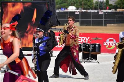 Students performing the 2021 show Phoenix Rising. A band member wears a sequined, long jacket of gold and red.